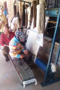 A rug weaver at a cooperative craft business.